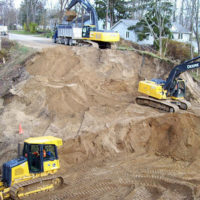 Heavy machinery prepping site for retaining wall