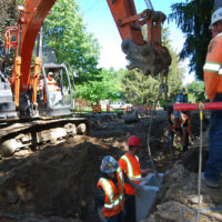 Crew working measuring placement of storm drain