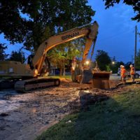 Workers filling hole at night